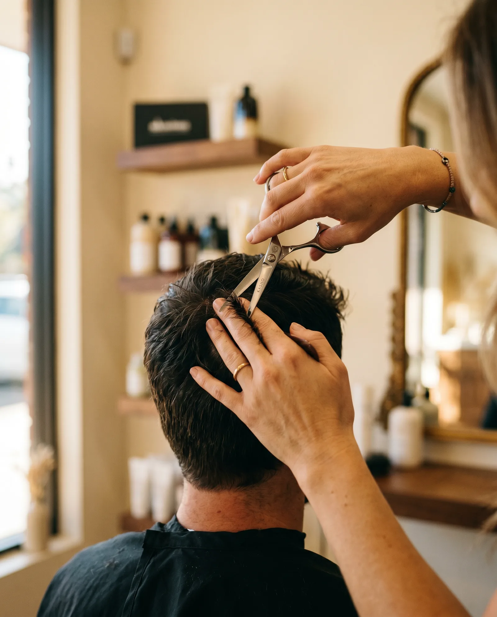 Barber's hands cutting a man's hair with precision in a Palo Alto salon